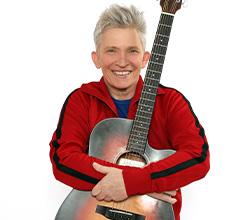 Suli Puschban mit Gitarre im Arm.
